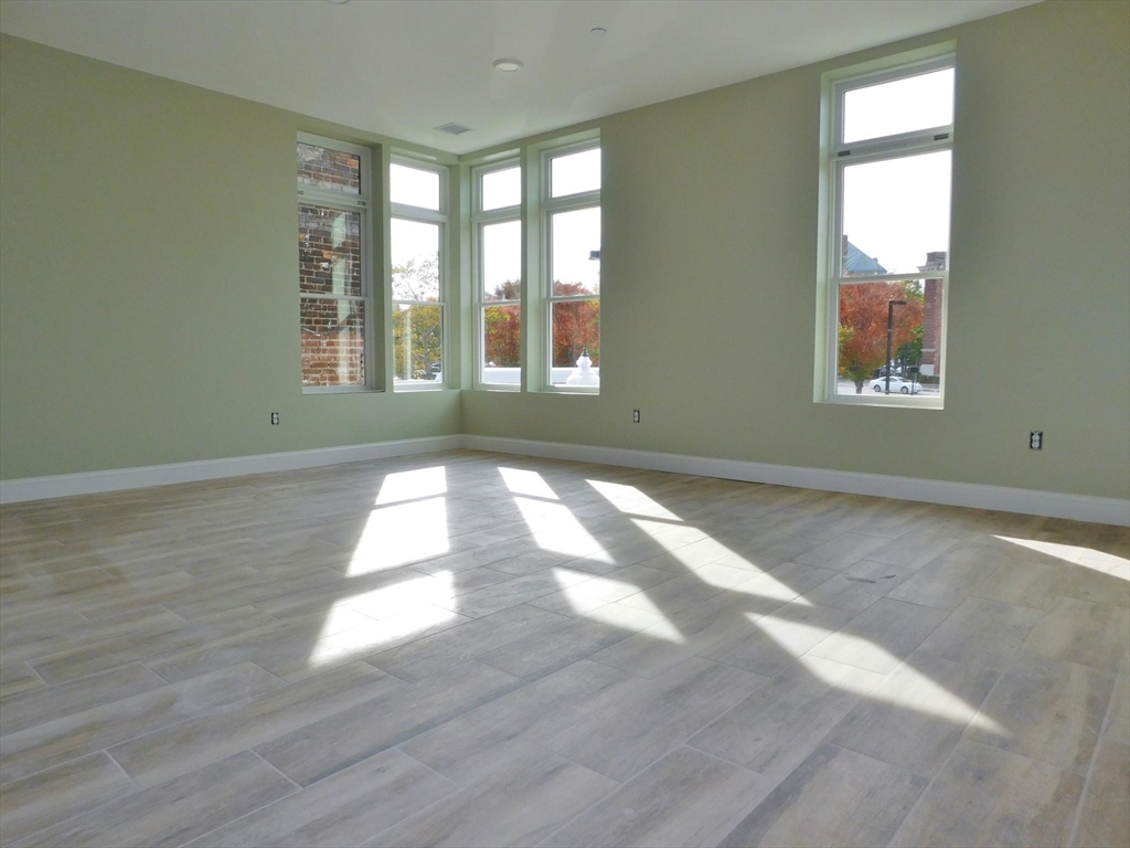 10 Roxbury Street, Unit 8 Boston, MA 02119 - Photo 6 of 10 a view of empty room with wooden floor and fan
