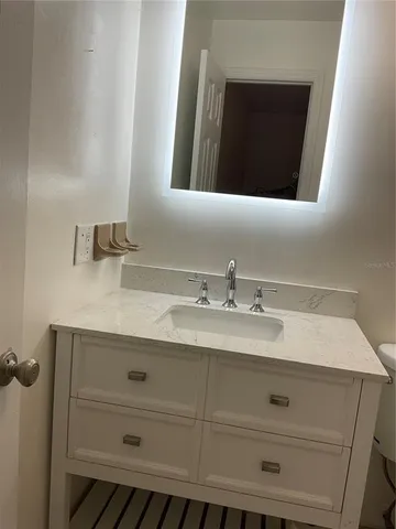 a bathroom with a sink vanity and mirror