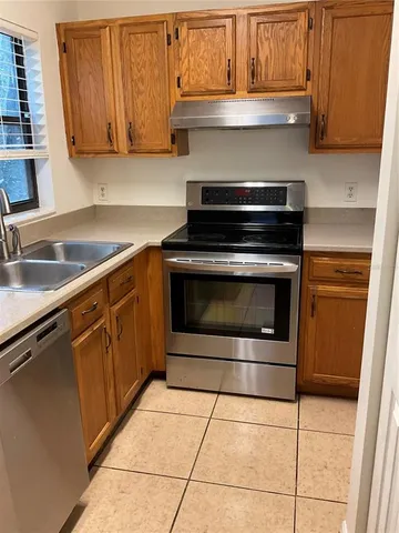 a kitchen with granite countertop a stove top oven microwave and cabinets
