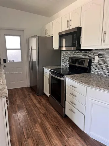 a kitchen with stainless steel appliances granite countertop a stove microwave and refrigerator