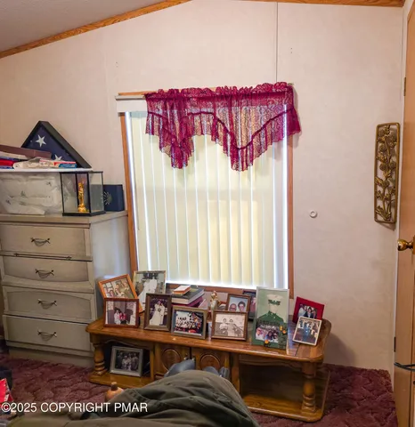 a view of a bedroom with furniture and window