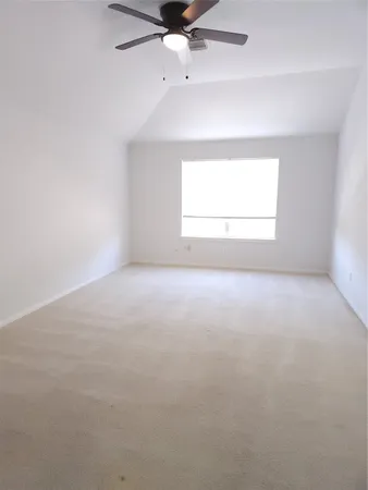 an empty room with a window and a ceiling fan