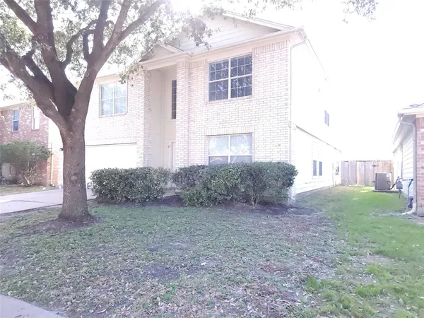 a view of a house with a yard and large tree