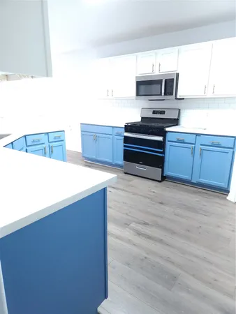 a kitchen with stainless steel appliances a stove and a microwave