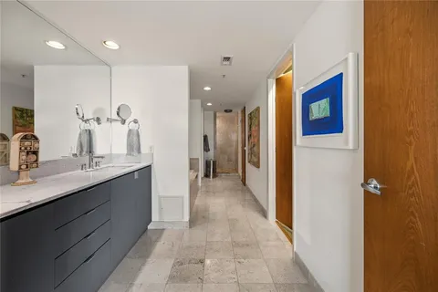 a bathroom with a double vanity sink mirror and shower