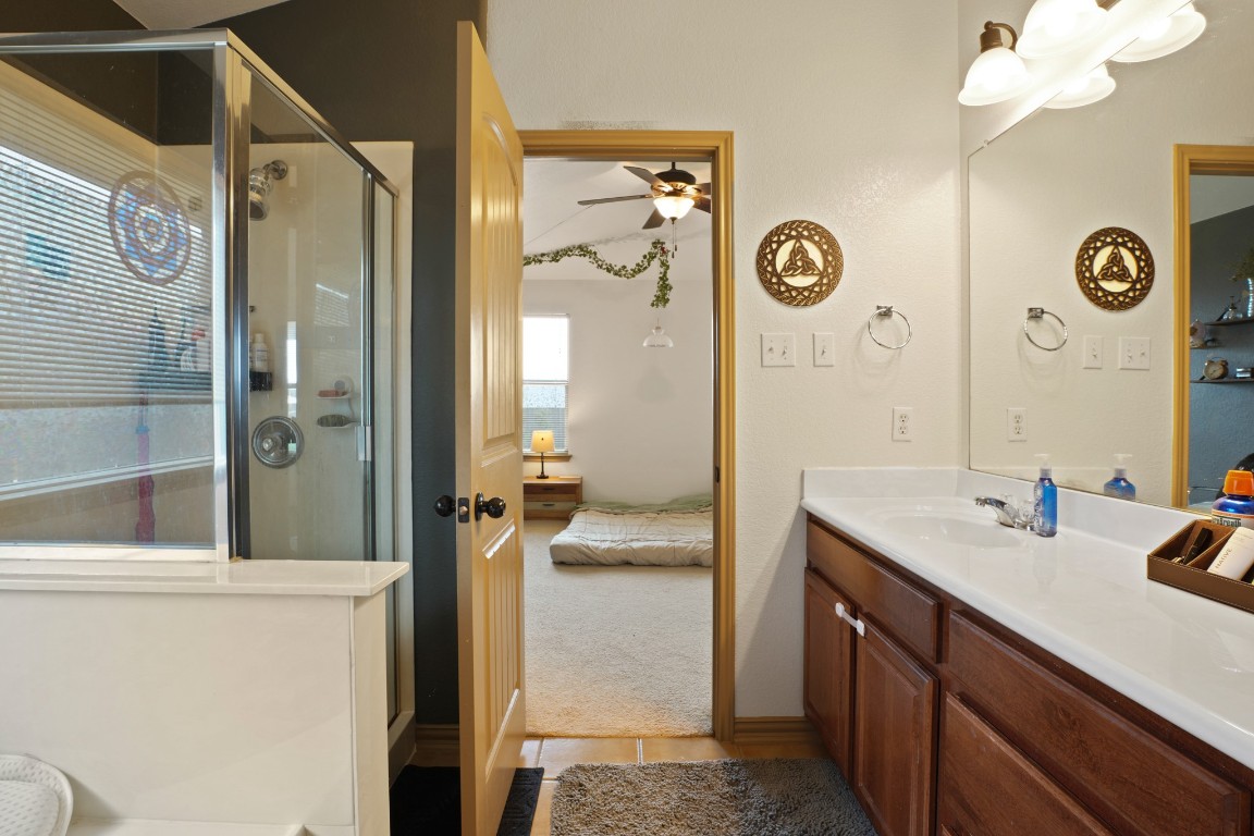 11012 Short Springs Drive Austin, TX 78754 - Photo 17 of 28 a bathroom with a sink a mirror and a shower