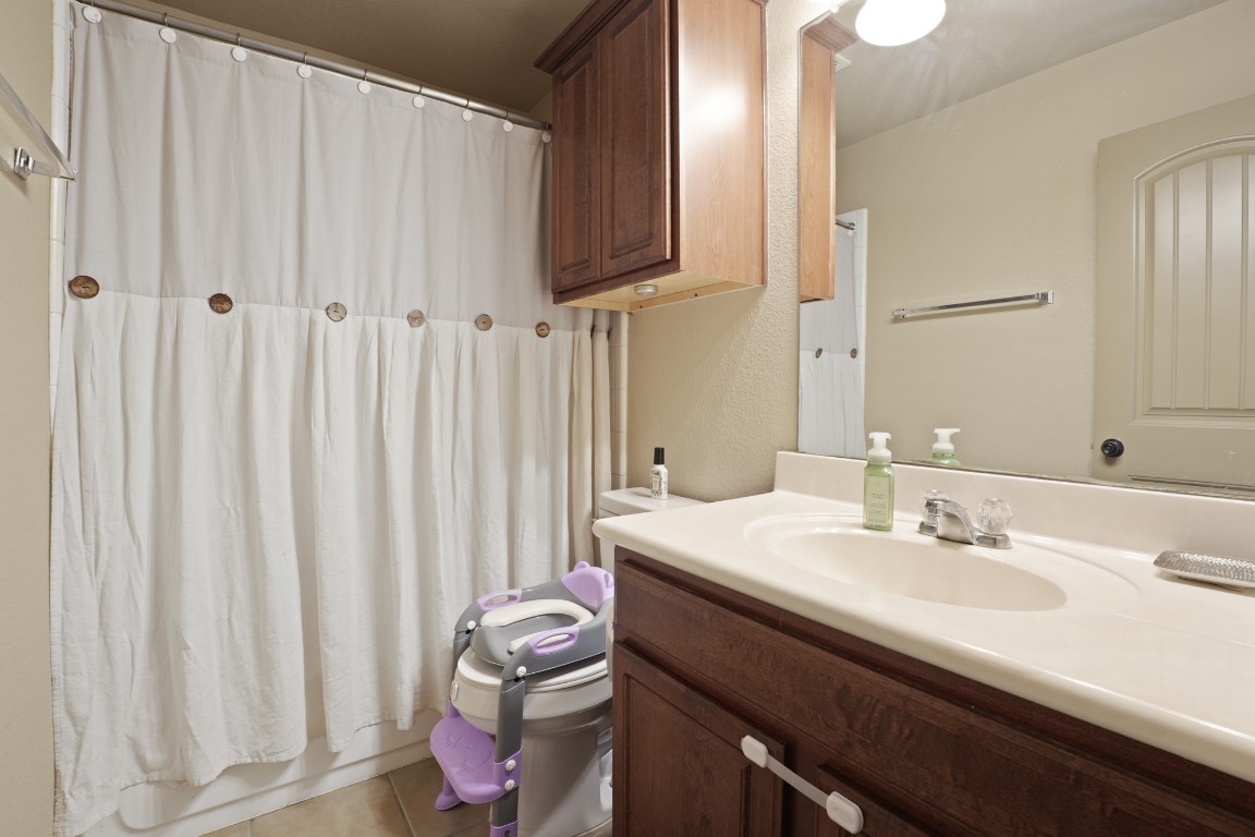 11012 Short Springs Drive Austin, TX 78754 - Photo 20 of 28 a bathroom with a sink a toilet and shower curtain
