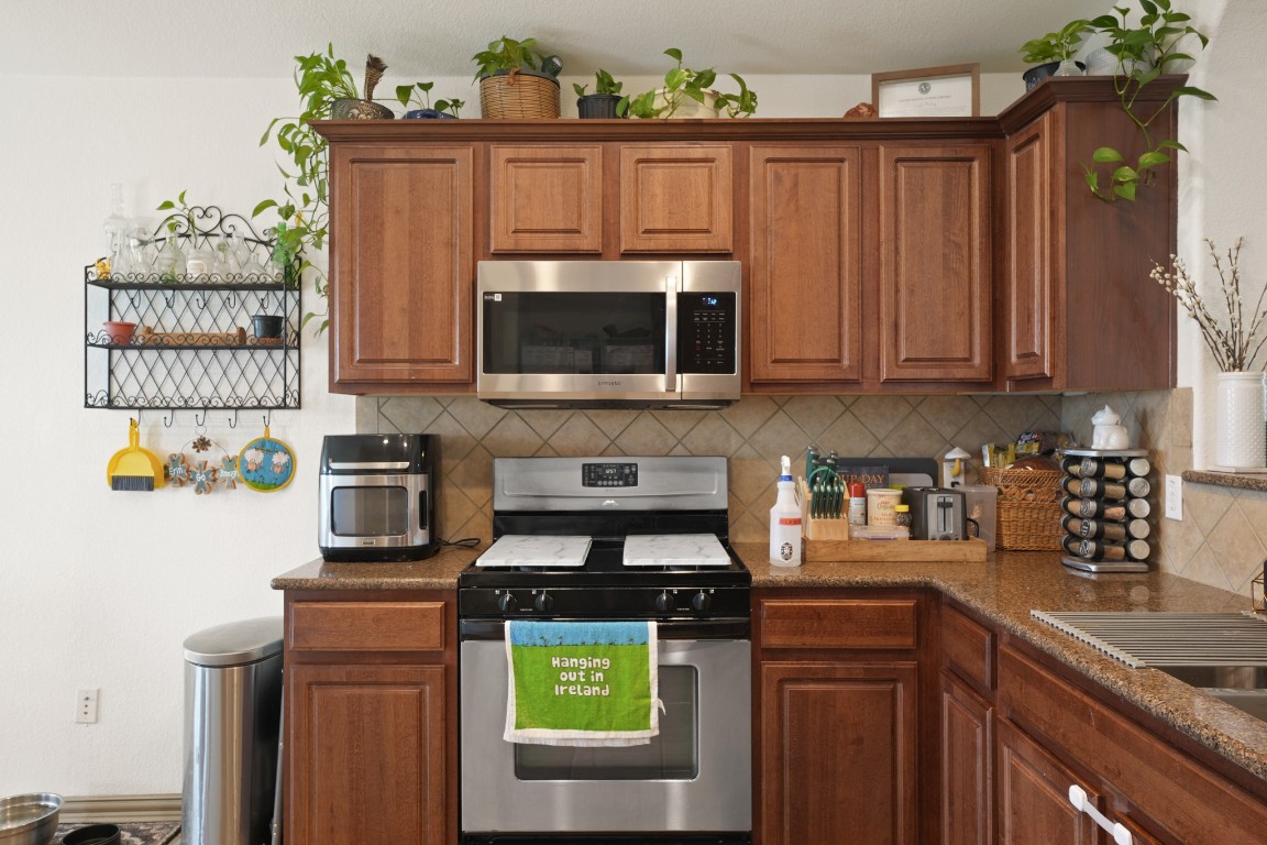 11012 Short Springs Drive Austin, TX 78754 - Photo 10 of 28 a kitchen with stainless steel appliances a stove a microwave a sink and cabinets
