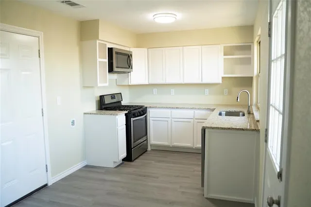 a kitchen with a sink a stove and cabinets