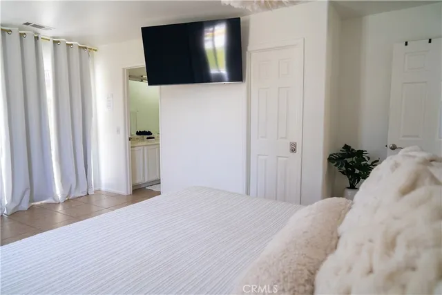 a bedroom with a bed and a flat screen tv