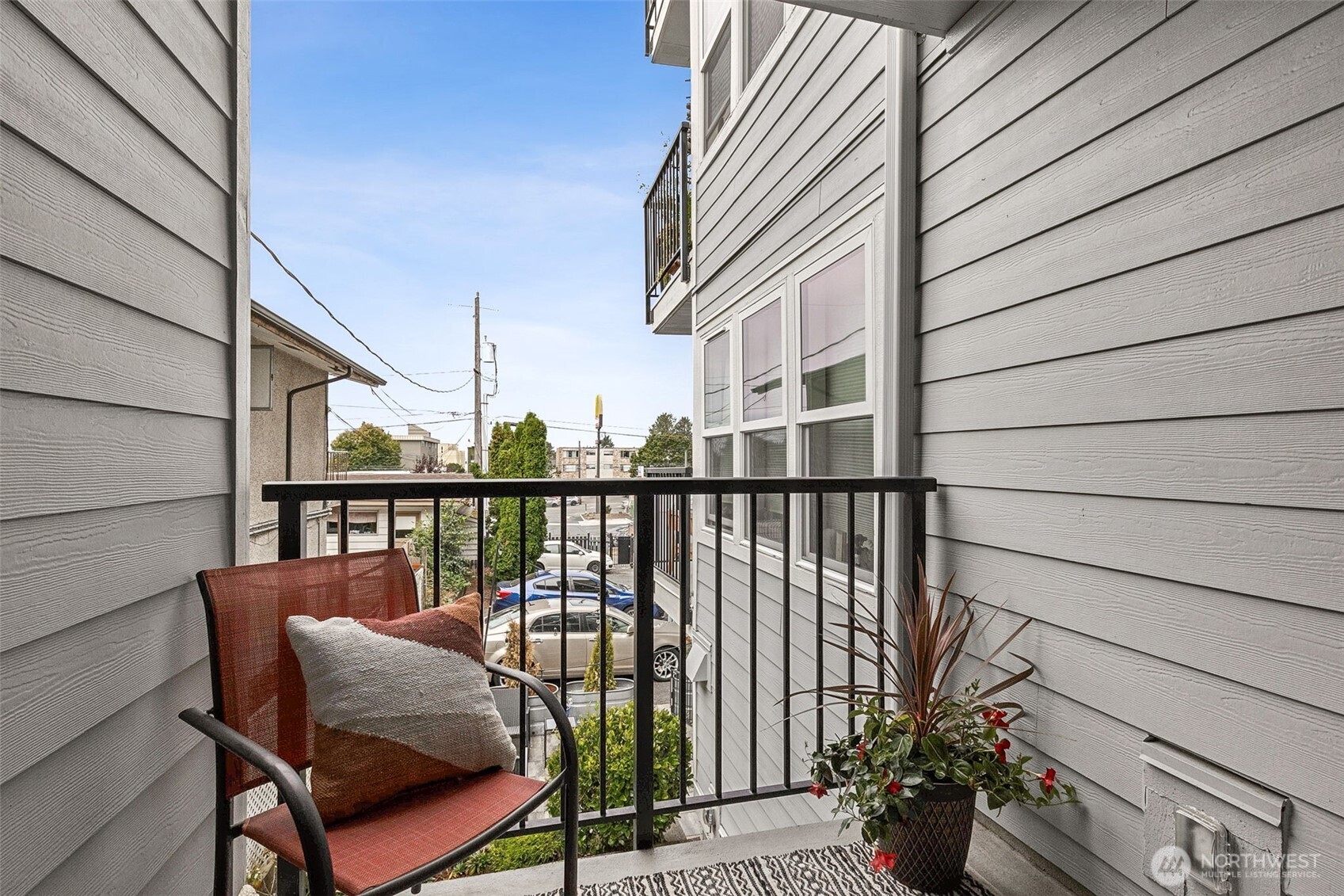6547 42nd Avenue Southwest, Unit 205 Seattle, WA 98136 - Photo 15 of 18 a balcony with couple of chairs and wooden fence