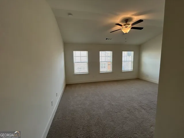 an empty room with closet and fan