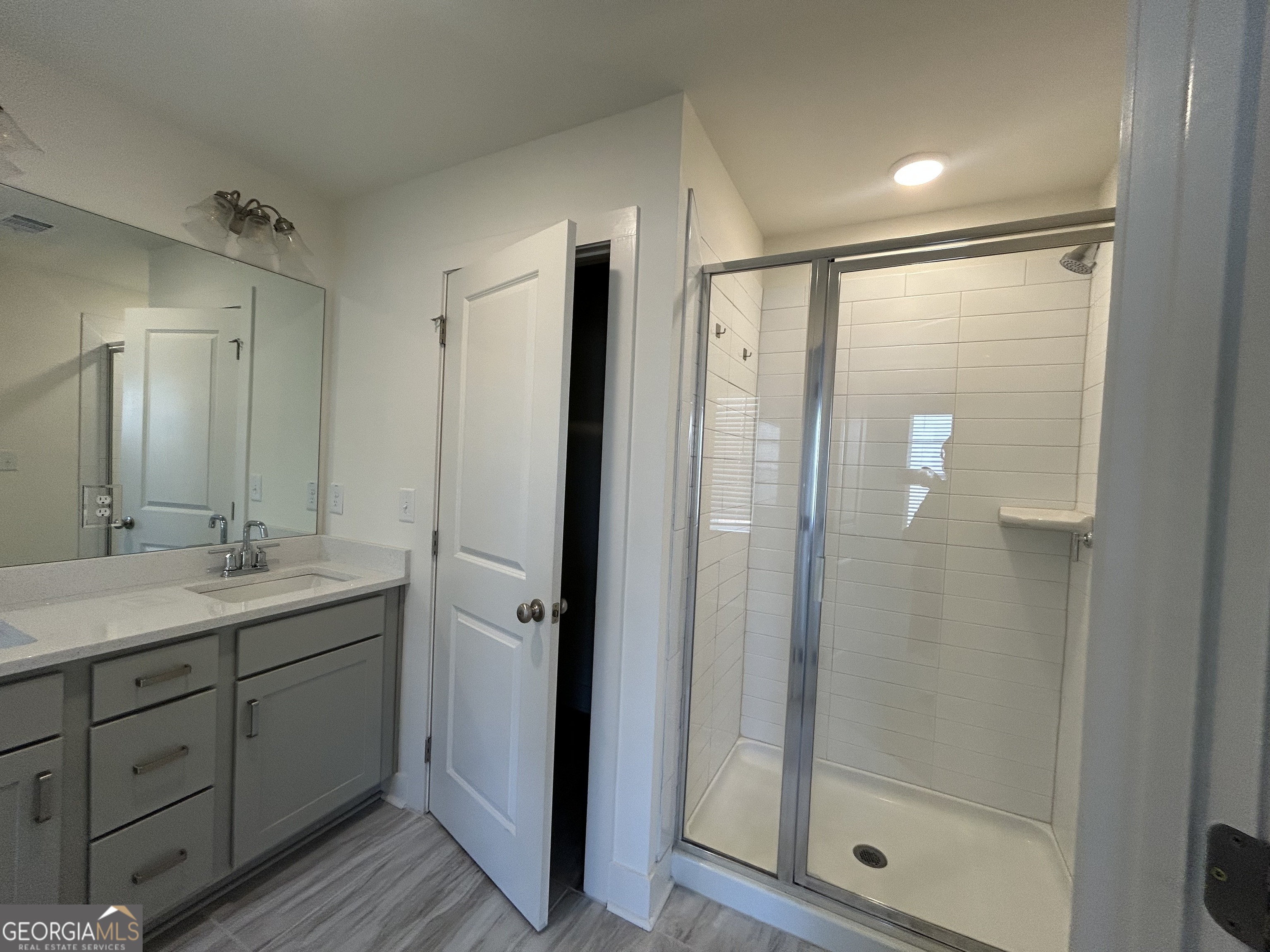 7741 Squire Court Fairburn, GA 30213 - Photo 22 of 25 a bathroom with a shower sink and mirror