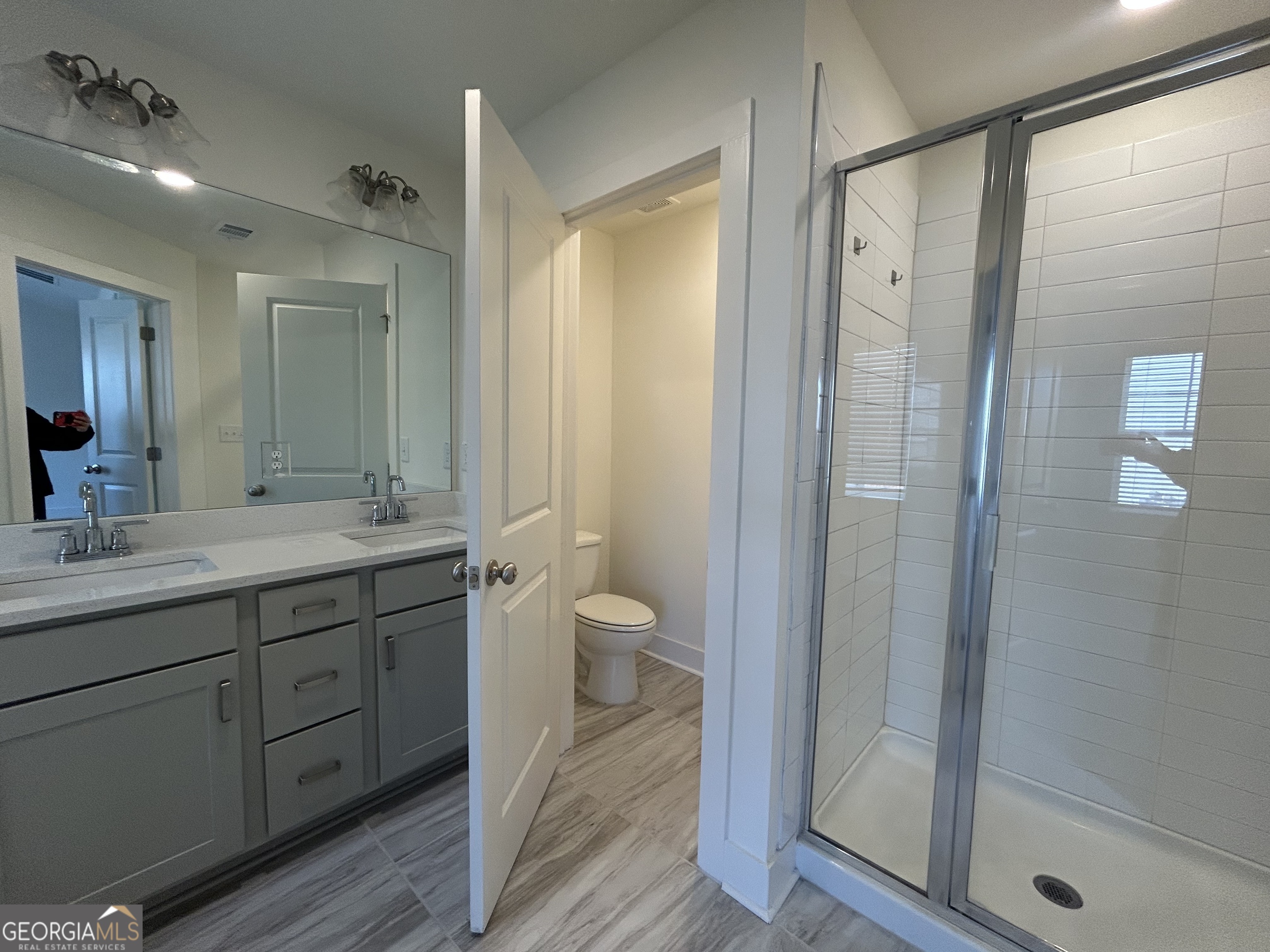 7741 Squire Court Fairburn, GA 30213 - Photo 24 of 25 a bathroom with a granite countertop sink a toilet and shower