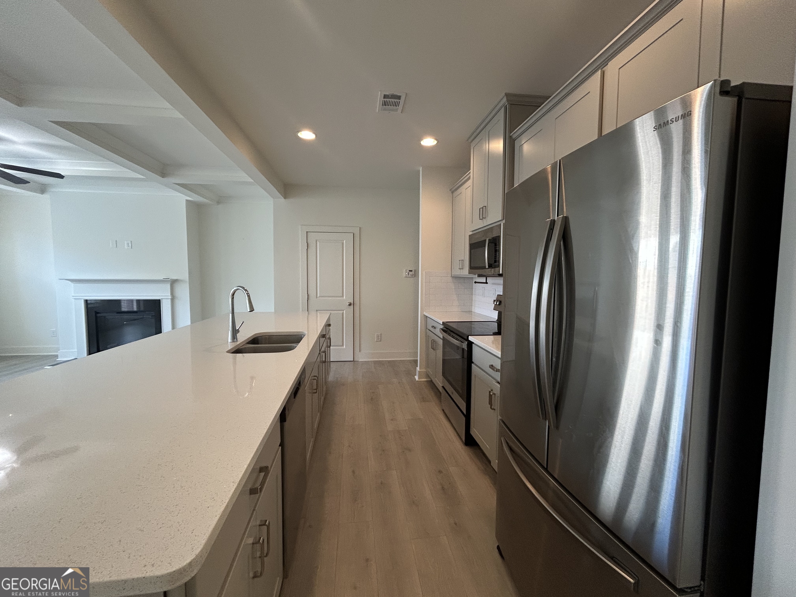 7741 Squire Court Fairburn, GA 30213 - Photo 5 of 25 a kitchen with stainless steel appliances a refrigerator sink and stove