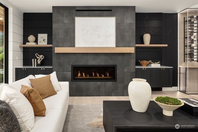 a living room with stainless steel appliances kitchen island granite countertop a table chairs refrigerator and sink