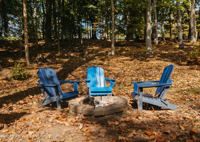 a view of a chairs and fire pit in the middle of a yard