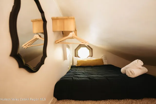 a bed sitting in a bedroom next to a window
