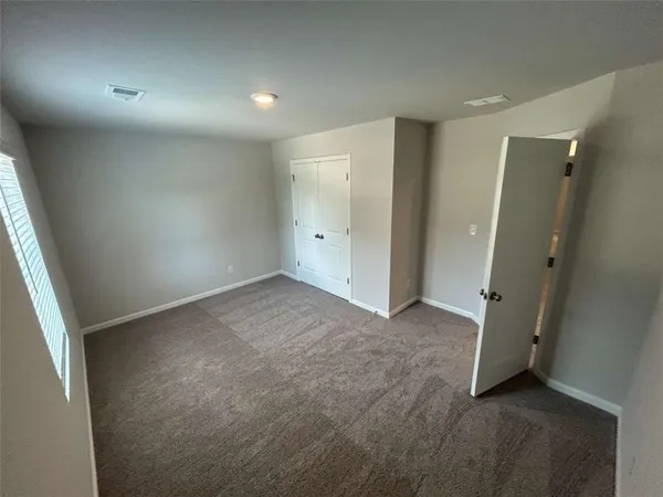 an empty room with a ceiling fan and a window