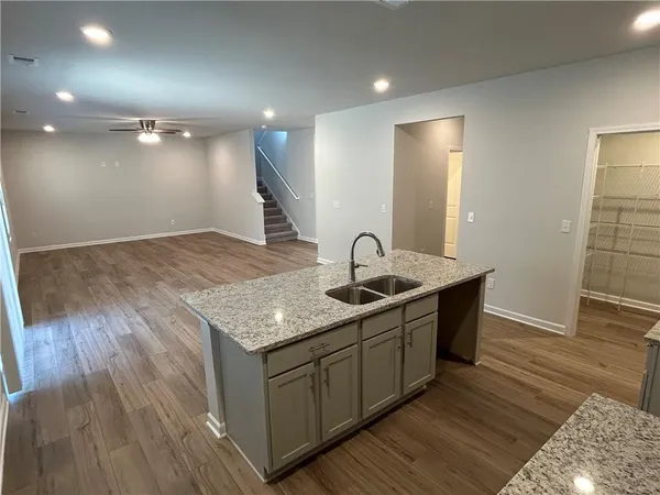 a kitchen with a sink and mirror with wooden floor