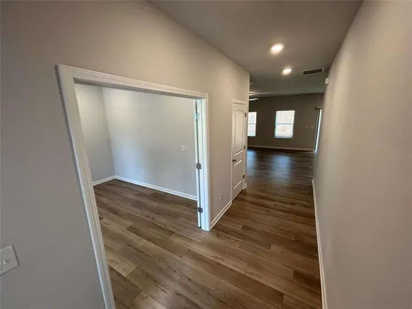 a view of a hallway with wooden floor