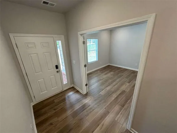 an empty room with wooden floor and closet