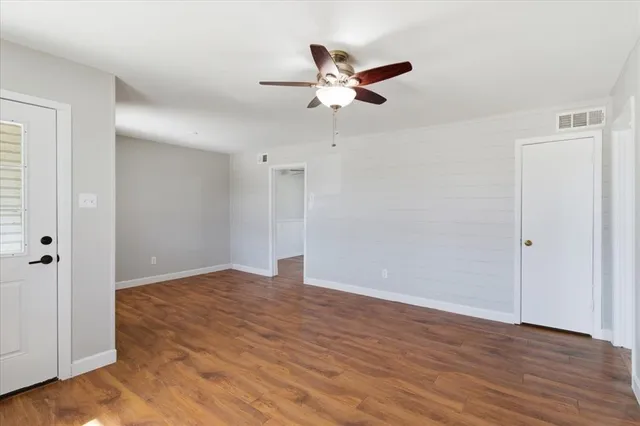 a view of an empty room with wooden floor