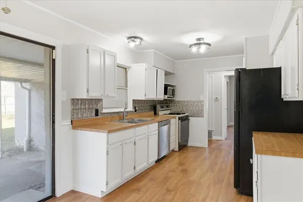 a kitchen with white cabinets and refrigerator