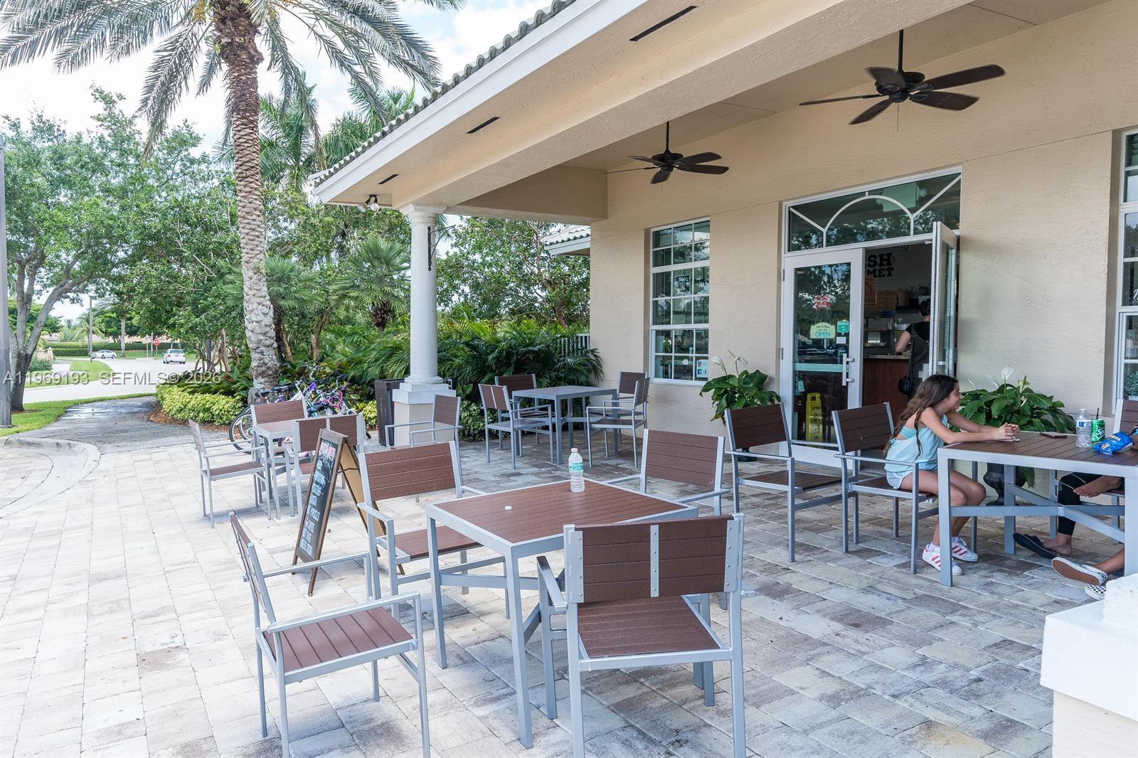 1653 Zenith Way Weston, FL 33327 - Photo 15 of 22 a view of a patio with table and chairs potted plants and floor to ceiling window