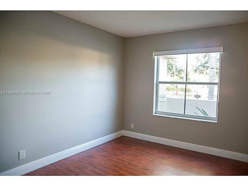 1653 Zenith Way Weston, FL 33327 - Photo 4 of 22 an empty room with wooden floor and windows