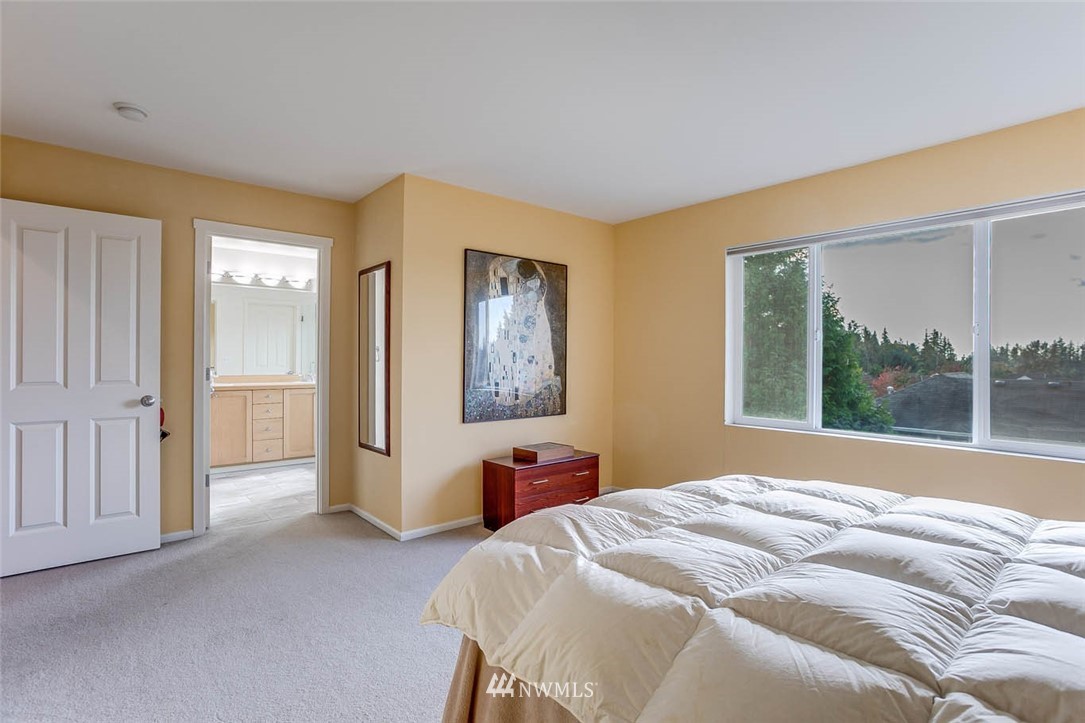 27555 Maple Ridge Way Southeast Maple Valley, WA 98038 - Photo 13 of 25 a bedroom with a bed and a large window