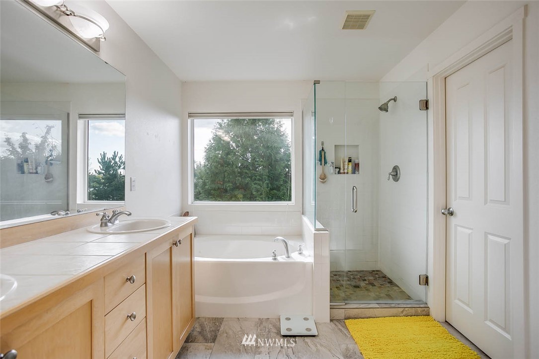 27555 Maple Ridge Way Southeast Maple Valley, WA 98038 - Photo 15 of 25 a bathroom with a tub sink and mirror