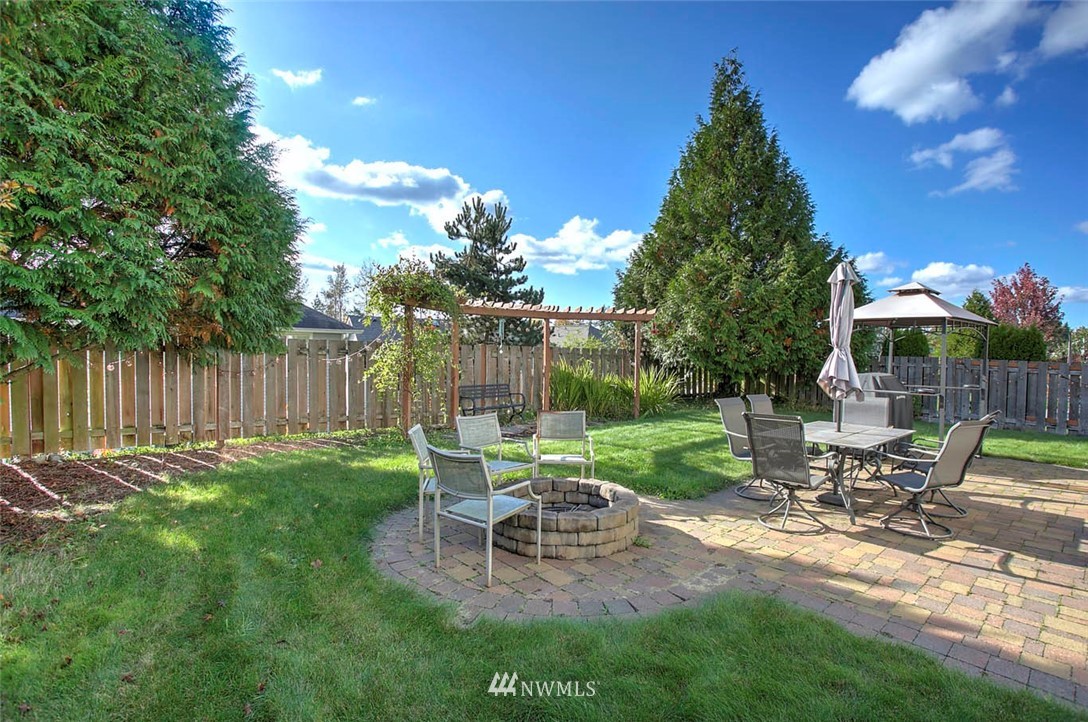 27555 Maple Ridge Way Southeast Maple Valley, WA 98038 - Photo 22 of 25 a view of a chair and table in backyard of the house
