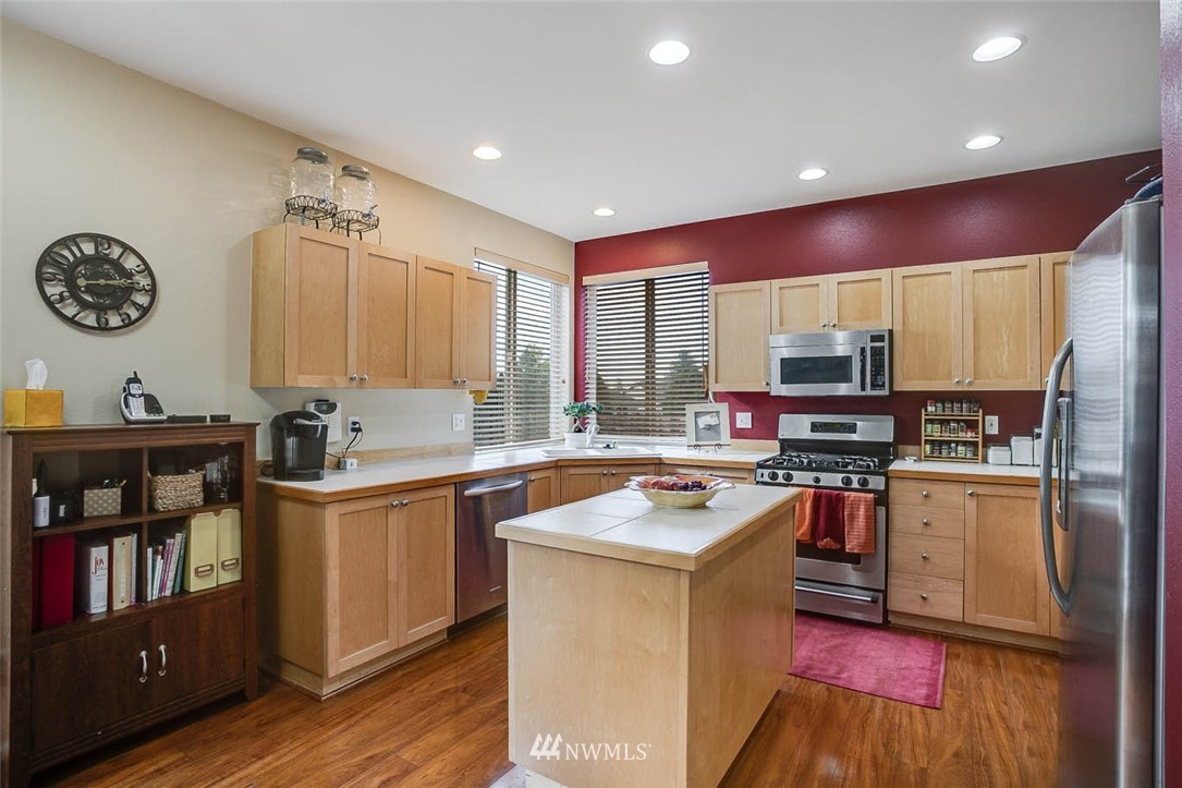 27555 Maple Ridge Way Southeast Maple Valley, WA 98038 - Photo 10 of 25 a kitchen with stainless steel appliances a stove top oven and a refrigerator