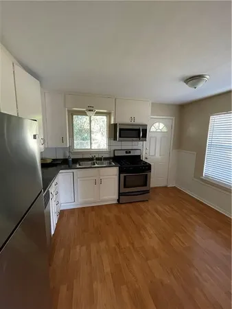 a kitchen with granite countertop a stove a sink and a refrigerator