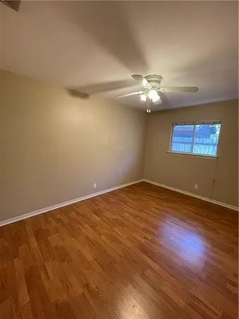 a view of a room with wooden floor and a ceiling fan