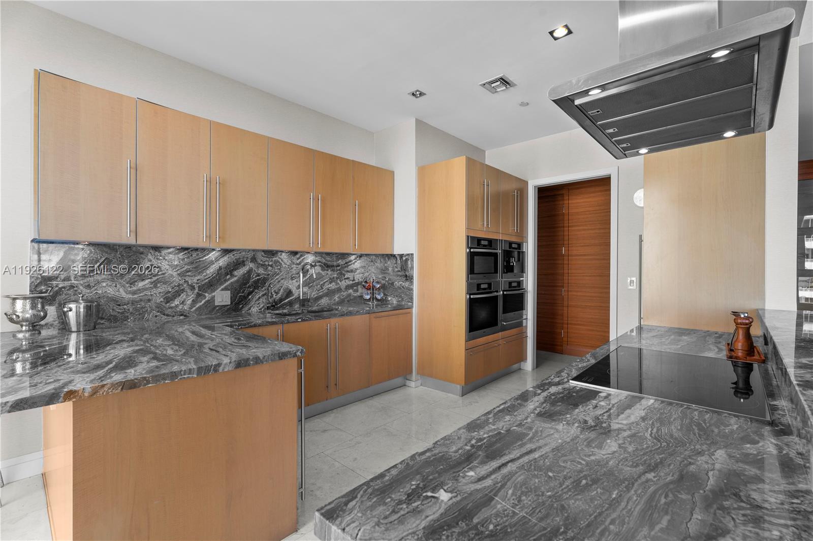 900 Brickell Key Boulevard, Unit 803 Miami, FL 33131 - Photo 11 of 38 a kitchen with stainless steel appliances granite countertop a sink refrigerator and cabinets