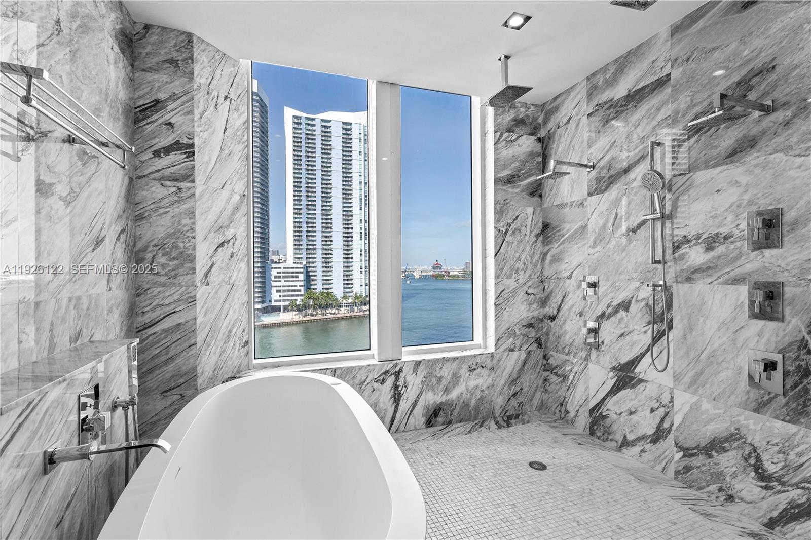 900 Brickell Key Boulevard, Unit 803 Miami, FL 33131 - Photo 18 of 38 a spacious bathroom with a bathtub and shower