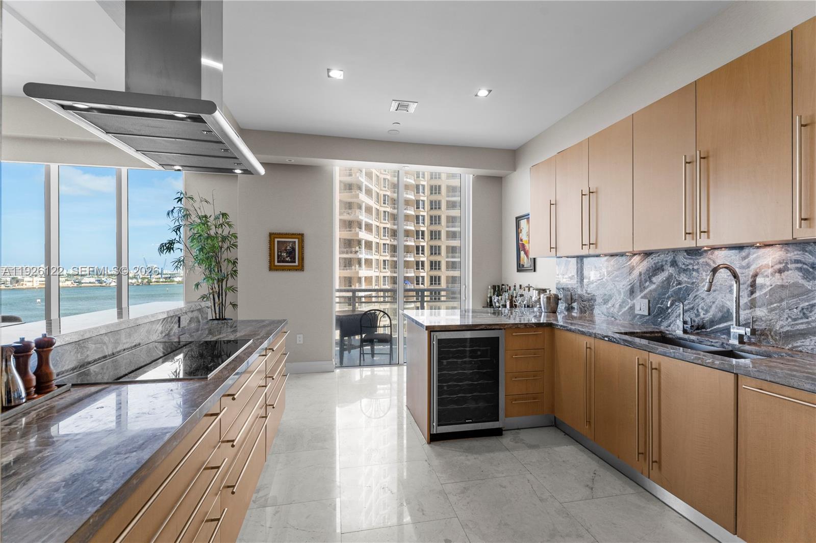 900 Brickell Key Boulevard, Unit 803 Miami, FL 33131 - Photo 5 of 38 a kitchen with granite countertop a stove and white cabinets