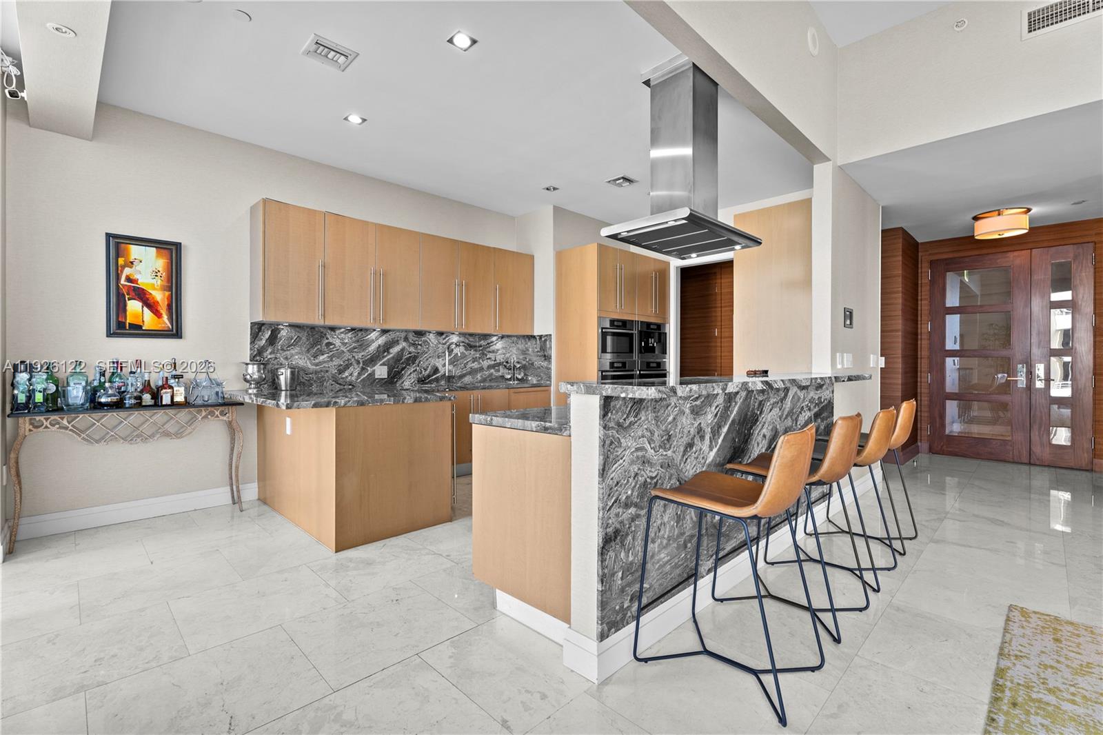 900 Brickell Key Boulevard, Unit 803 Miami, FL 33131 - Photo 10 of 38 a kitchen with stainless steel appliances kitchen island granite countertop a stove a sink and a refrigerator