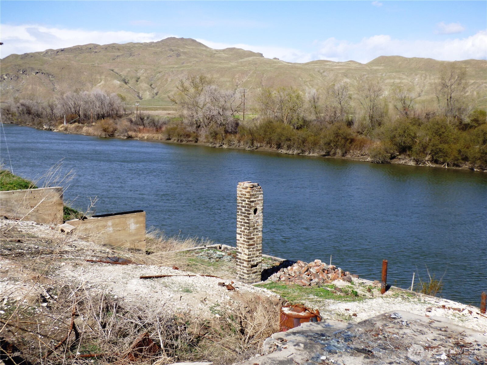 608 Monse River Road Brewster, WA 98812 - Photo 2 of 7 a view of a backyard with water and mountain view