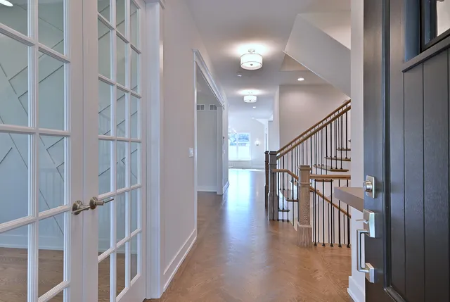 a view of staircase with lots of frames on wall and wooden floor