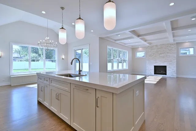 a kitchen with cabinets a sink dishwasher a dining table and chairs with wooden floor