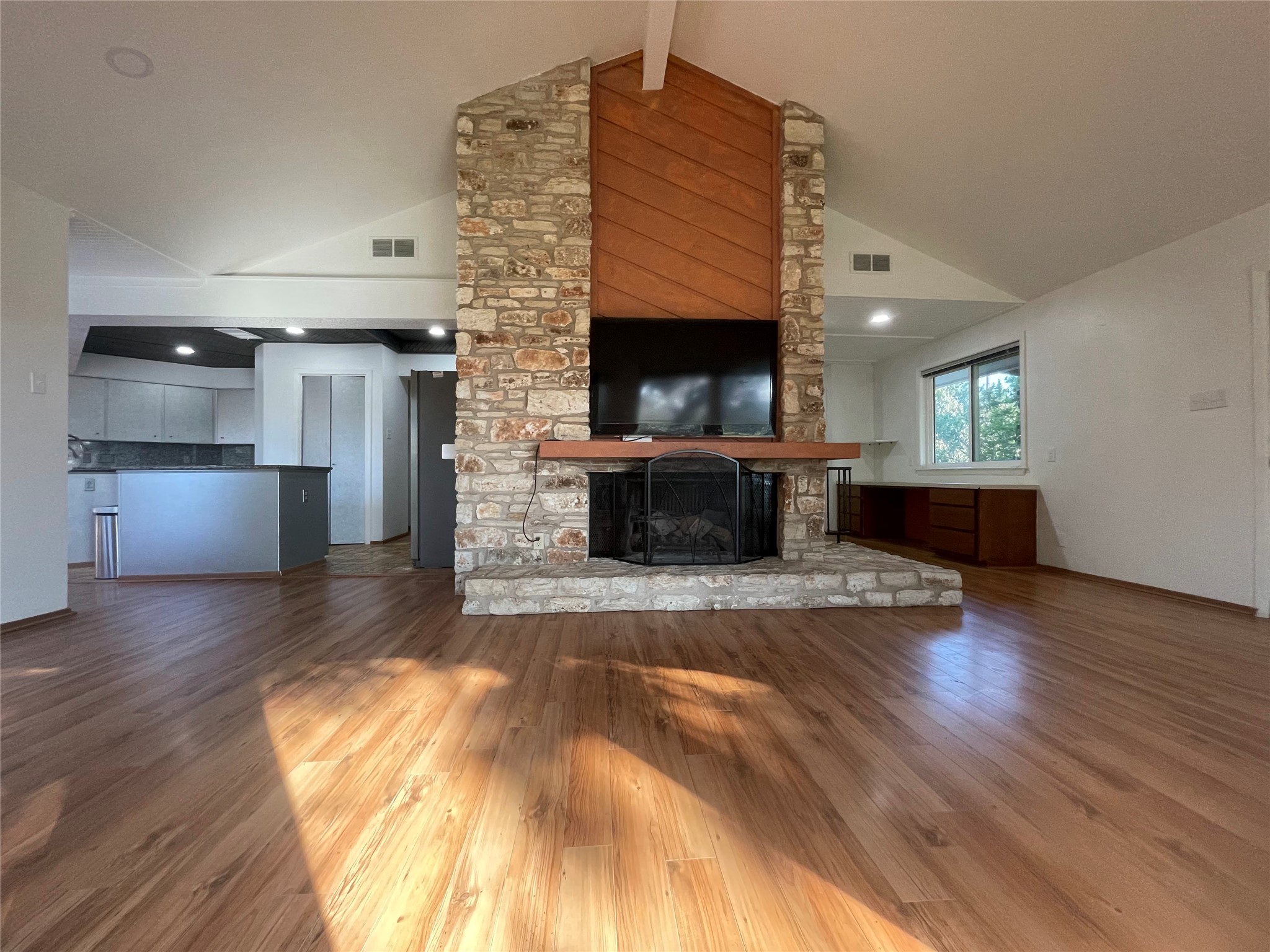 5802 Longhorn Landing Austin, TX 78734 - Photo 13 of 38 Unfurnished living room featuring wood finished floors and a stone fireplace