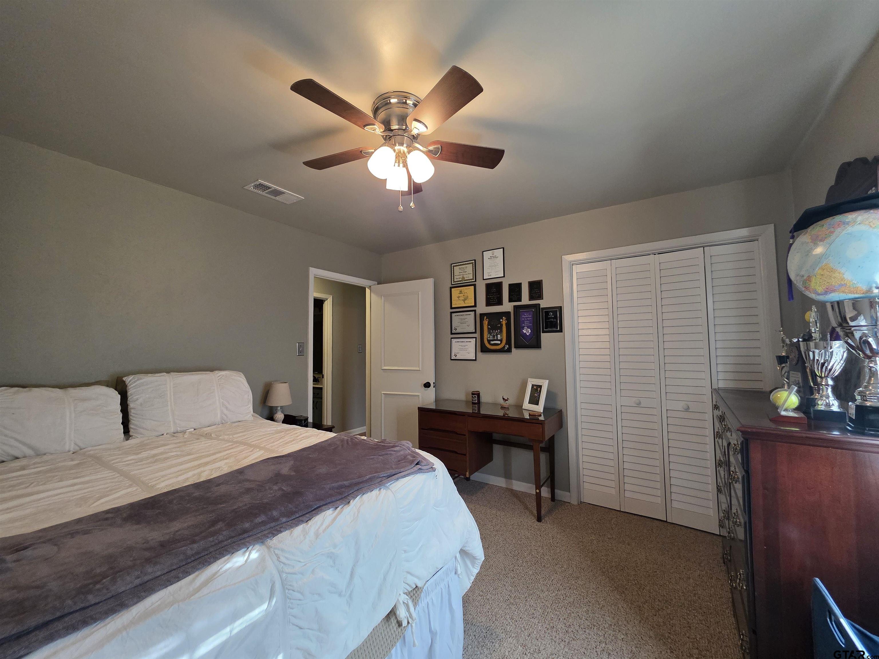 109 Randal Lane Pittsburg, TX 75686 - Photo 15 of 22 a bedroom with a bed and a chandelier