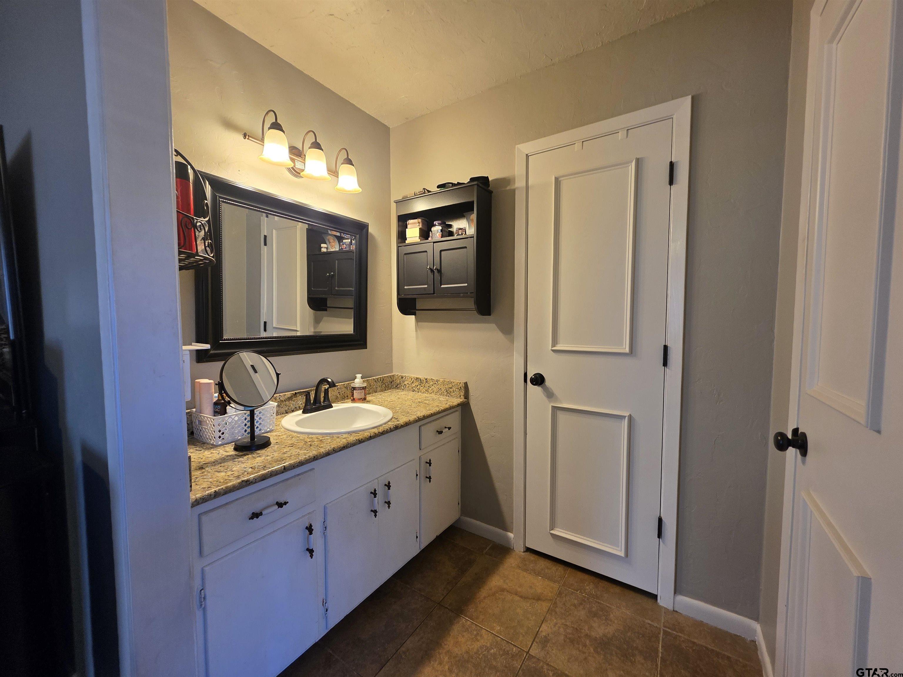 109 Randal Lane Pittsburg, TX 75686 - Photo 18 of 22 a bathroom with double vanity sink and a mirror