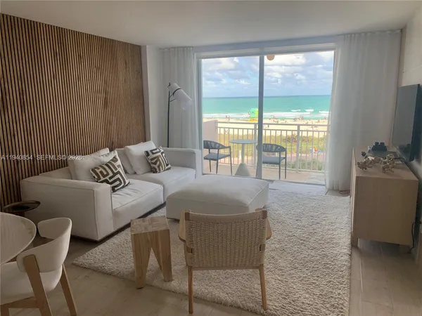 a living room with furniture and a floor to ceiling window