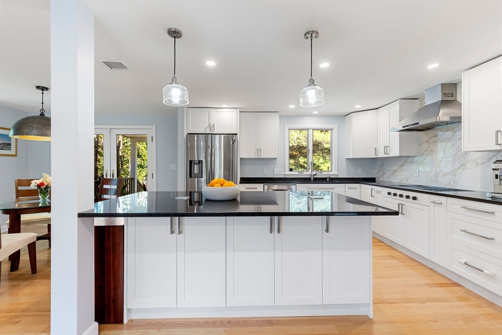 30 Granite Street Dedham, MA 02026 - Photo 5 of 36 a kitchen with kitchen island granite countertop a sink cabinets and window