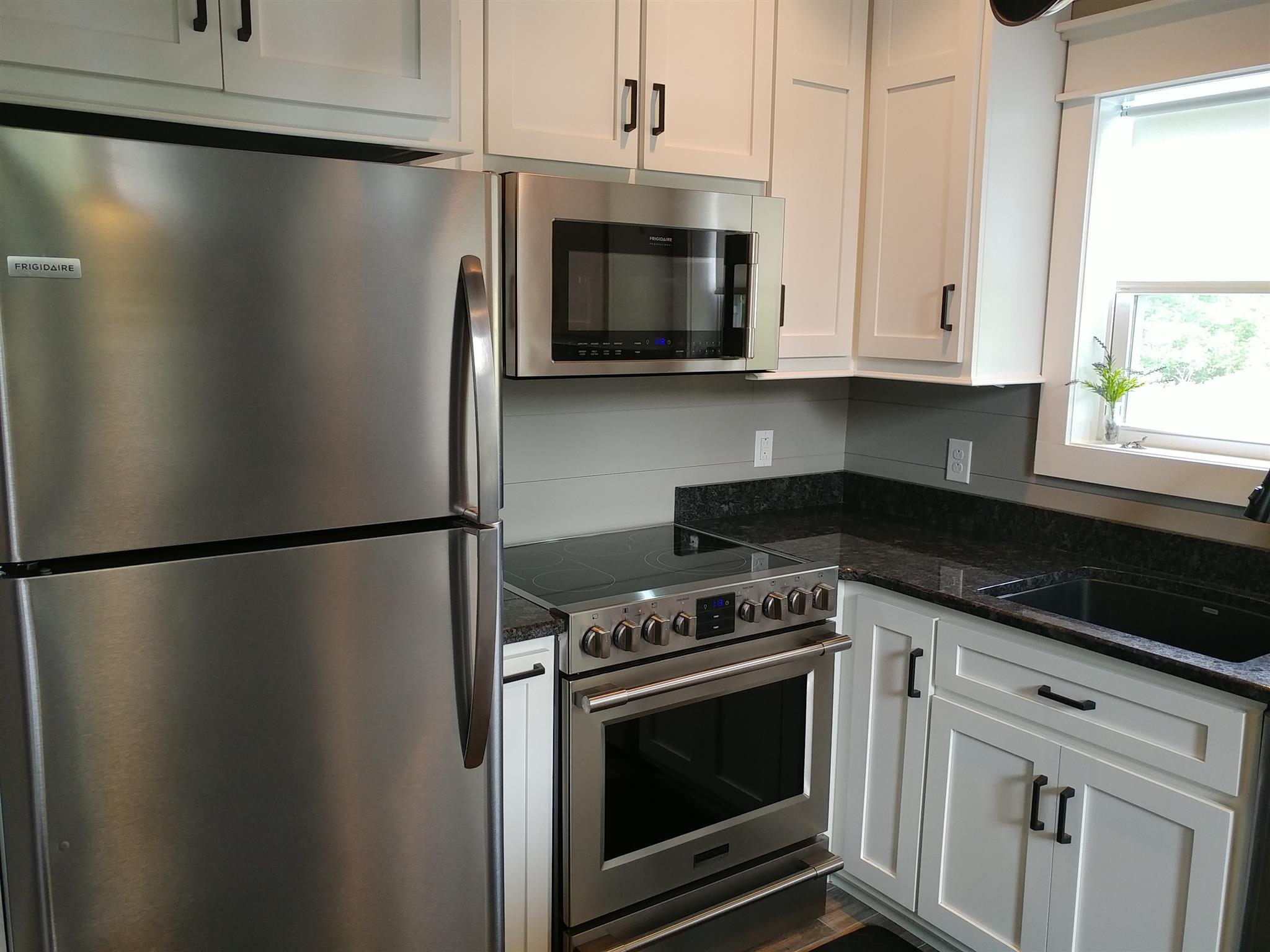 4055 Flewellyn Road Springfield, TN 37172 - Photo 9 of 28 a kitchen with stainless steel appliances white cabinets white stove a microwave and a refrigerator