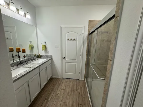 a bathroom with a sink a mirror a vanity and a shower